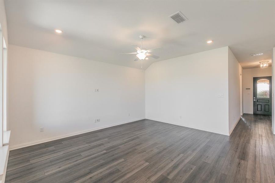 Empty room featuring ceiling fan and dark hardwood / wood-style floors