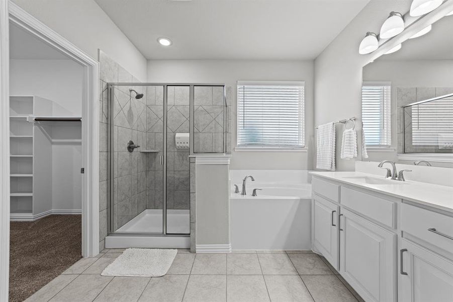 Bathroom with vanity, tile patterned floors, and shower with separate bathtub