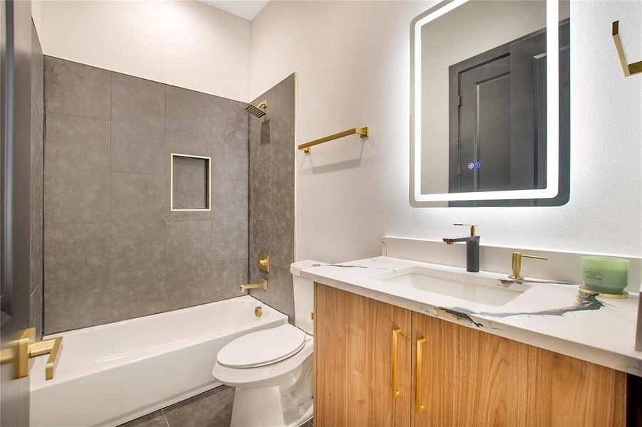 Full bathroom with vanity, tiled shower / bath, tile patterned flooring, and toilet
