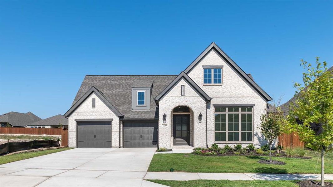 View of front of home with a front yard and a garage