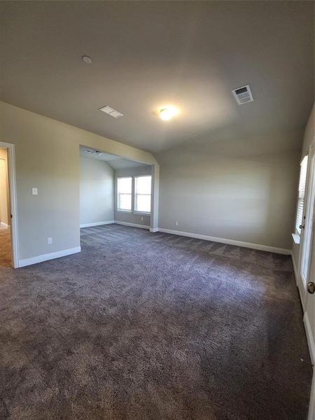 Spare room with lofted ceiling and dark colored carpet