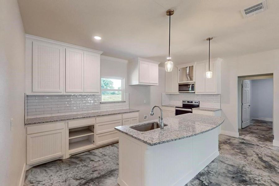 Kitchen featuring tasteful backsplash, white cabinets, stainless steel appliances, hanging light fixtures, and sink