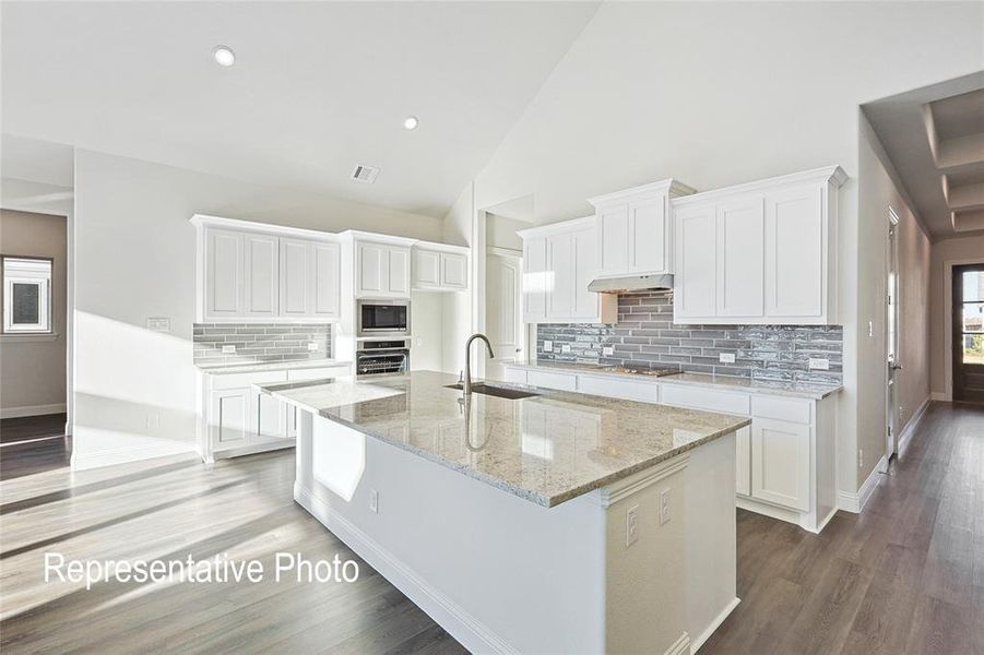 Kitchen featuring stainless steel appliances, white cabinetry, and tasteful backsplash