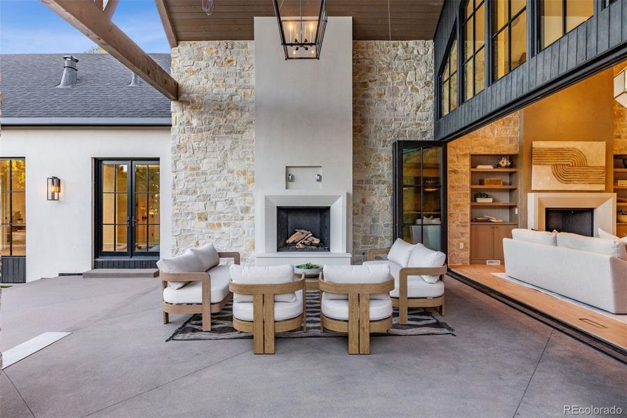 Covered Patio in Backyard with Limestone Fireplace