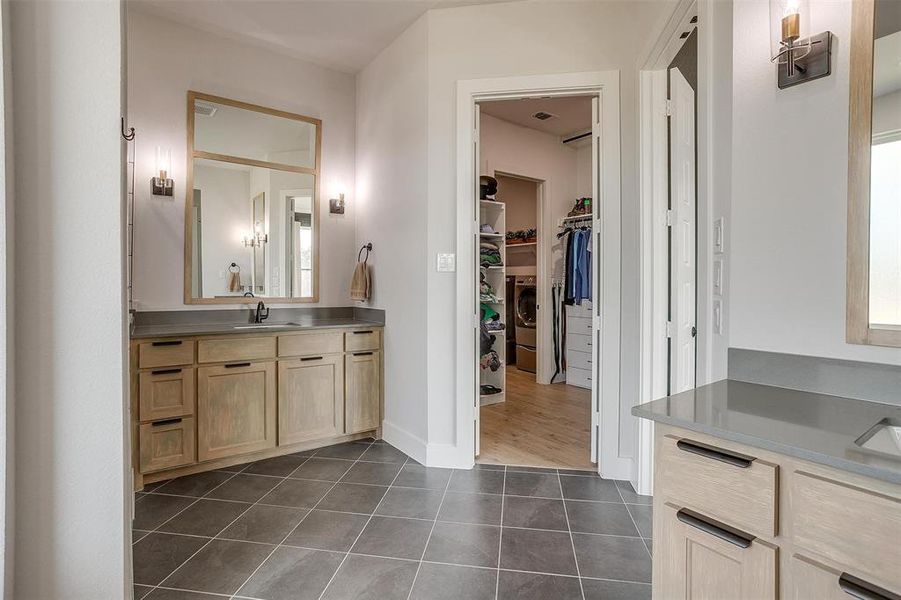 Bathroom featuring vanity, washer / clothes dryer, and tile patterned flooring