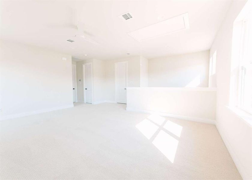 Carpeted spare room featuring ceiling fan