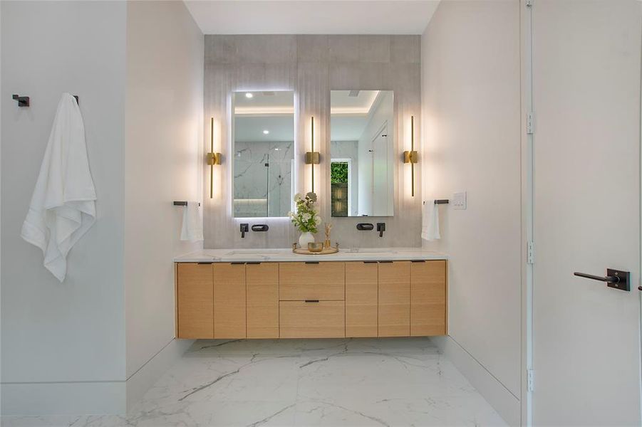 Bathroom featuring dual bowl vanity, tile flooring, and tasteful backsplash
