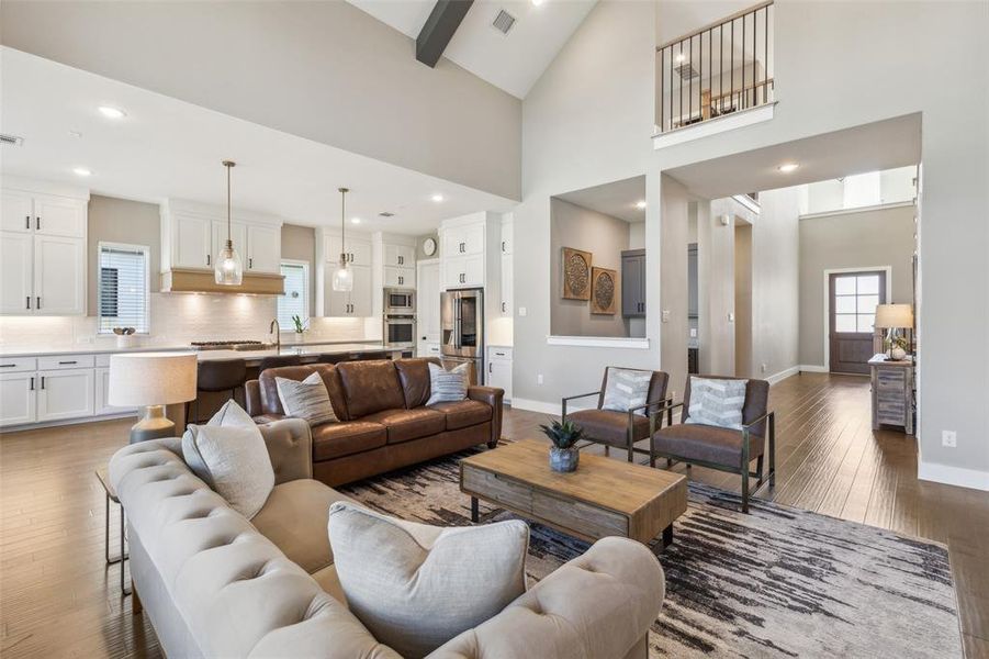 Living room with high vaulted ceiling and hardwood / wood-style flooring