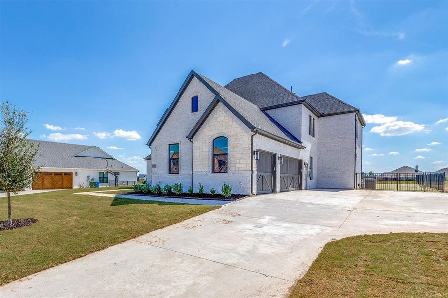 French provincial home with cooling unit, a front lawn, and a garage