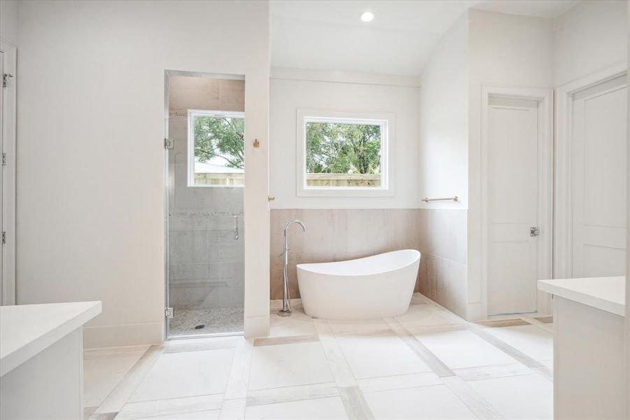 A walk in shower with bench seating, private water closet and separate soaking tub complete this master bath.