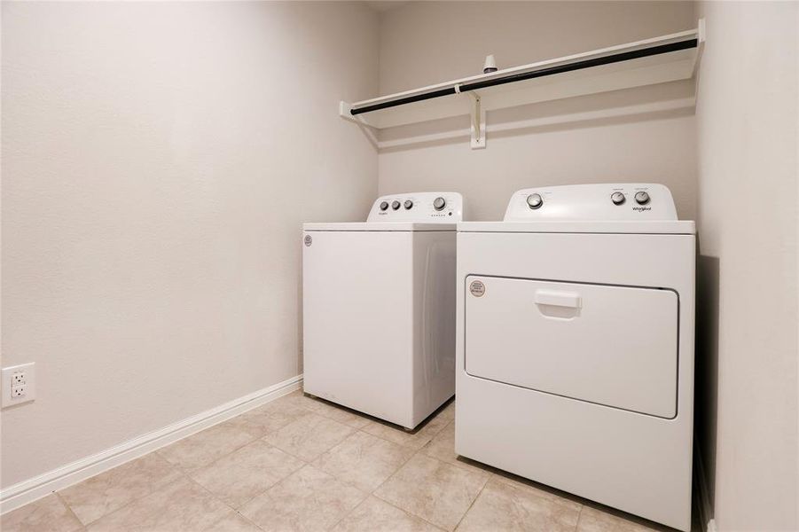 Laundry area featuring washer and dryer and light tile floors