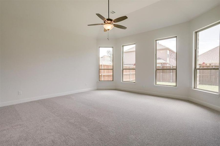 Carpeted empty room featuring ceiling fan