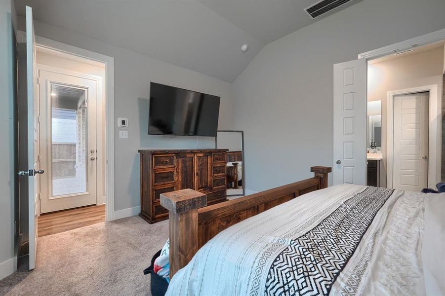 Bedroom featuring vaulted ceiling and light colored carpet