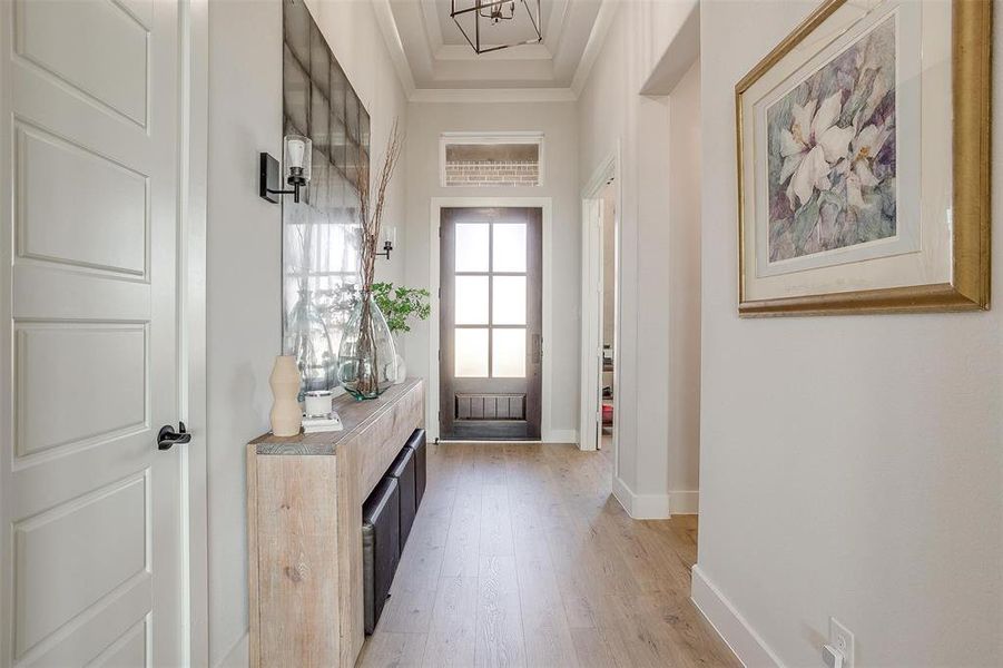 Entryway featuring crown molding and light wood-type flooring