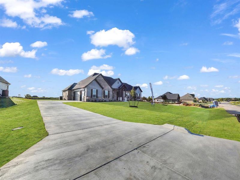 View of front facade featuring a garage and a front lawn