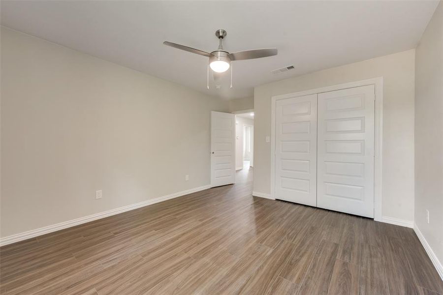 Unfurnished bedroom featuring ceiling fan, hardwood / wood-style flooring, and a closet