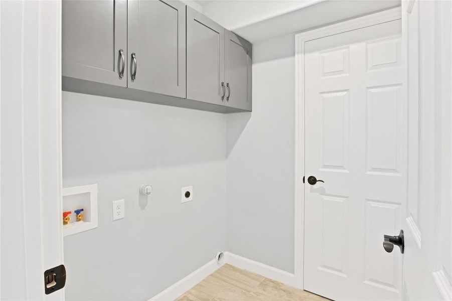 Laundry room featuring built-in cabinets and utility closet.