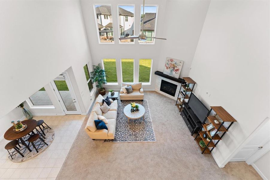 From above, the living room showcases its expansive layout with high ceilings and wide windows overlooking the backyard.