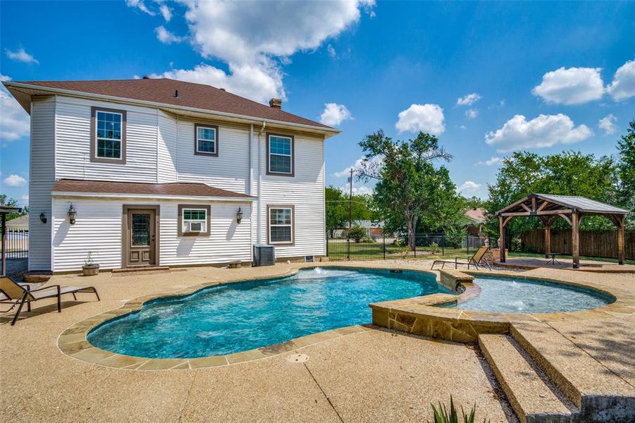 View of pool featuring pool water feature, central AC, a patio area, and a gazebo