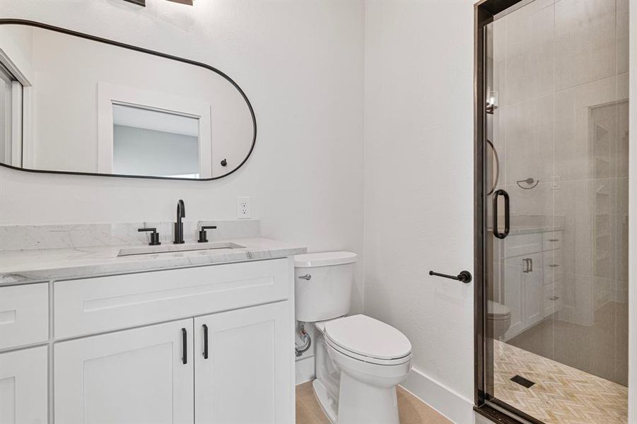 Bathroom with walk in shower, toilet, and large vanity