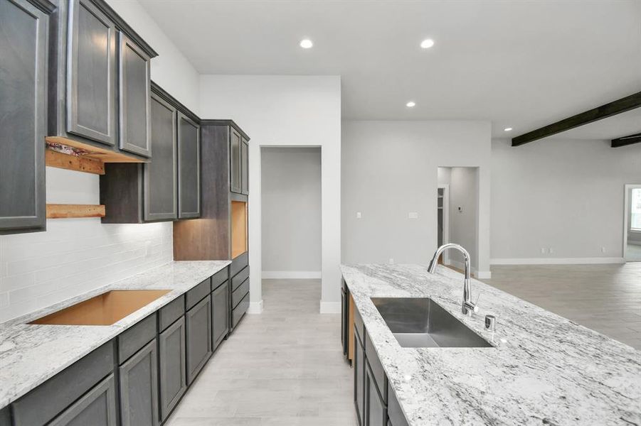 Discover another perspective of this stunning kitchen, generously appointed with an abundance of counter space.