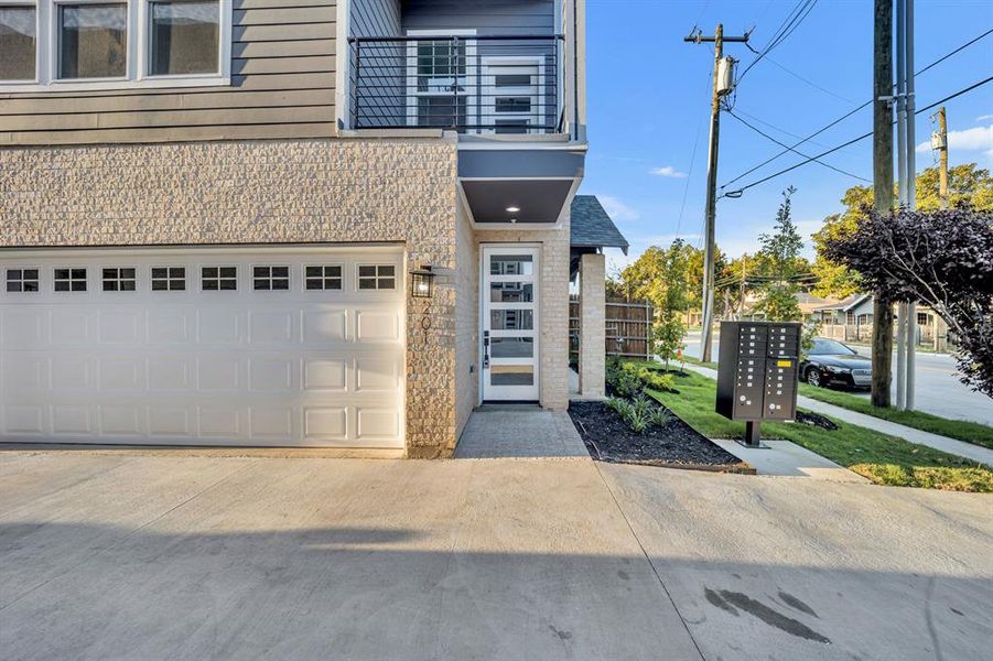 View of front of property featuring a balcony and a garage