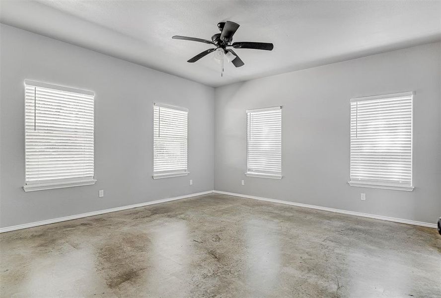 Spare room with concrete flooring and ceiling fan