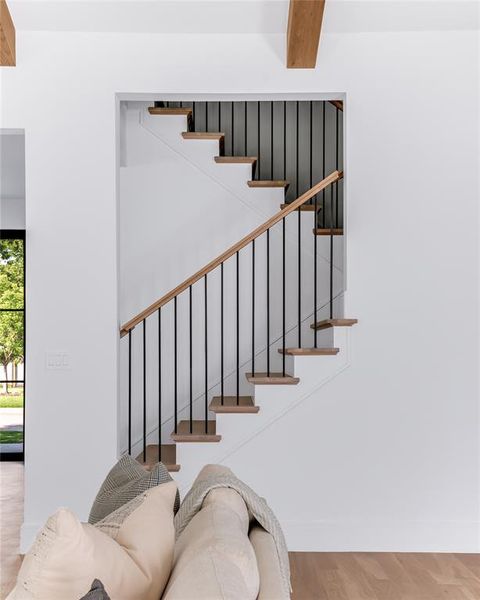 Stairway featuring hardwood / wood-style flooring and beamed ceiling