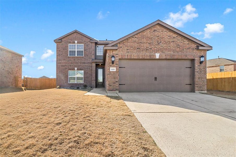 Front of property with a garage and a front lawn