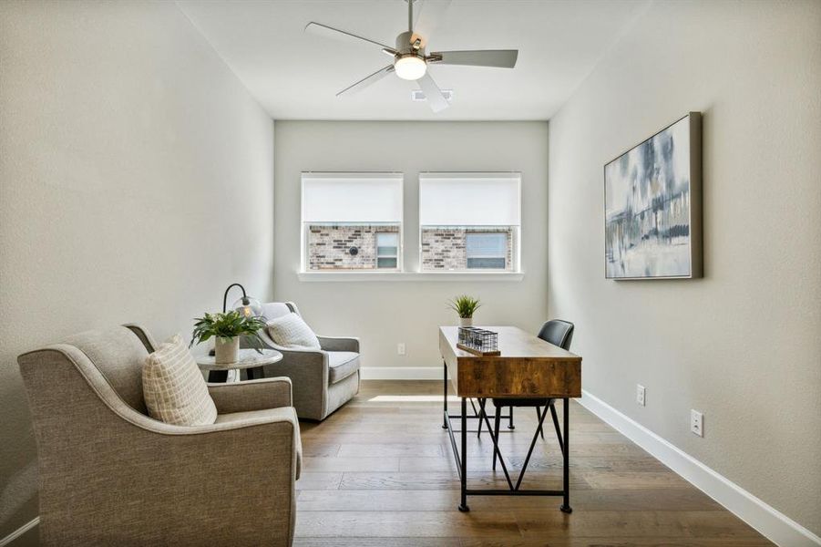 Home office with ceiling fan and hardwood / wood-style flooring