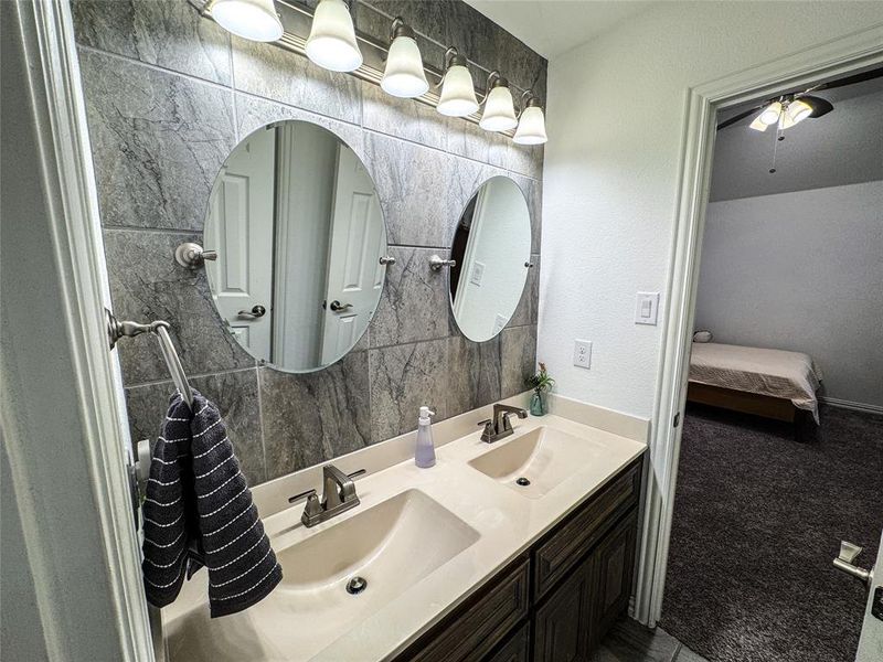 Bathroom with vanity, tile walls, and ceiling fan