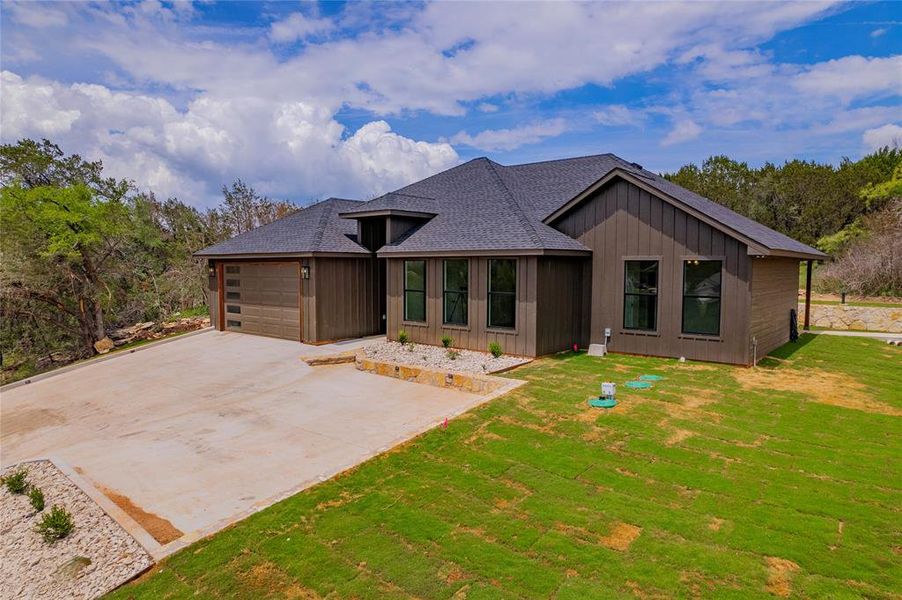 Back of property with a garage and a yard