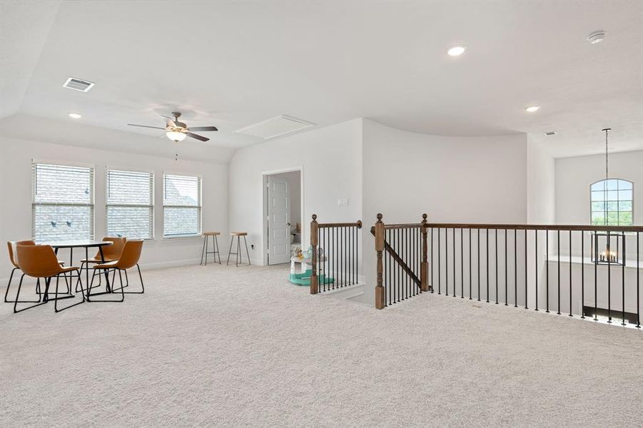 Sitting room with light carpet, ceiling fan, and a healthy amount of sunlight