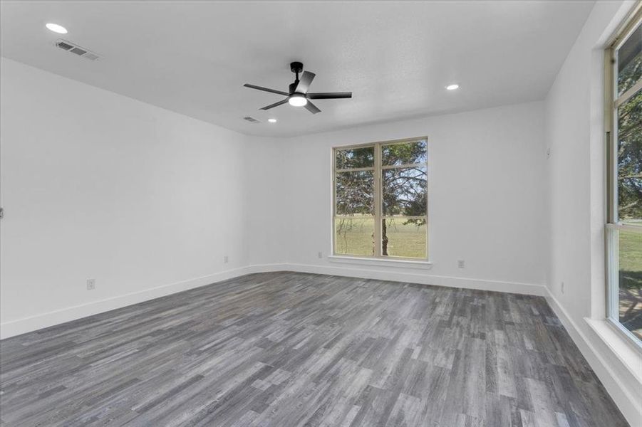 Unfurnished room with dark wood-type flooring and ceiling fan