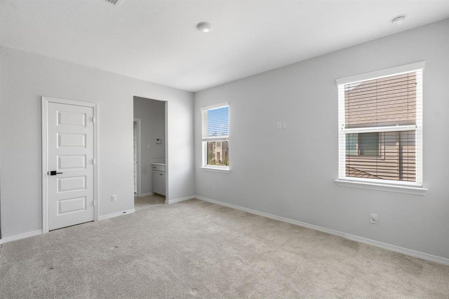 The fourth bedroom upstairs features plush carpet and large windows.