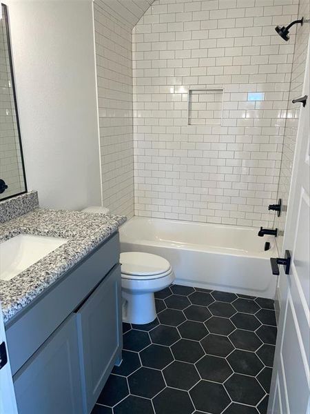 Full bathroom featuring tile floors, tiled shower / bath combo, toilet, and vanity
