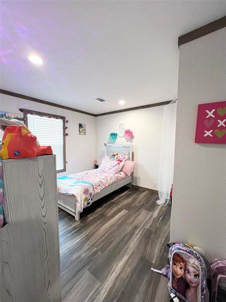 Bedroom featuring crown molding and dark hardwood / wood-style flooring