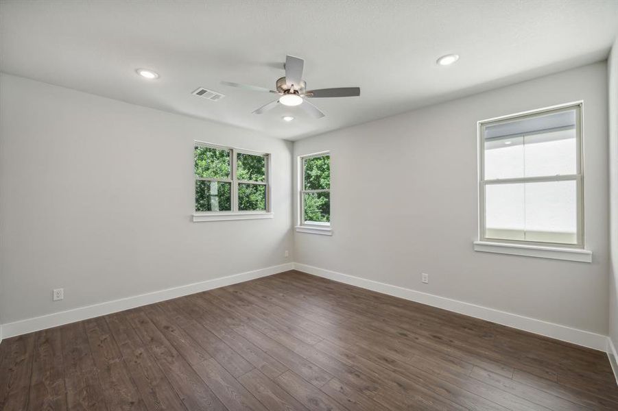 Unfurnished room featuring dark wood-type flooring and ceiling fan