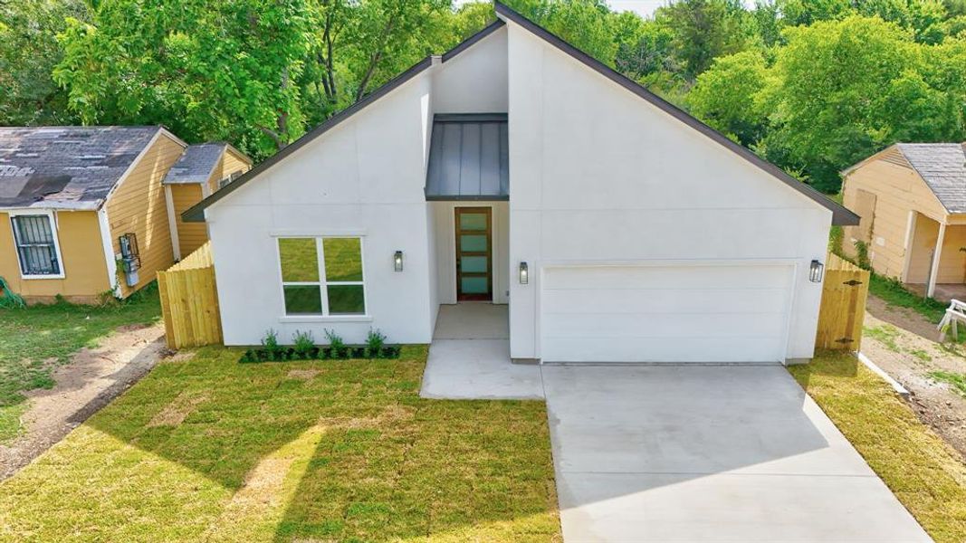 View of front facade with a front lawn and a garage