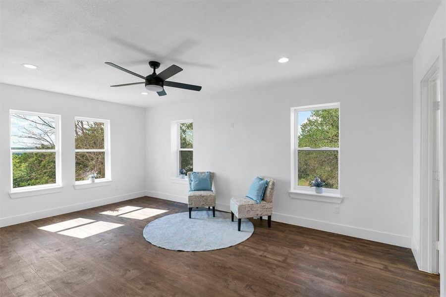 Unfurnished room with a healthy amount of sunlight, ceiling fan, and dark hardwood / wood-style flooring