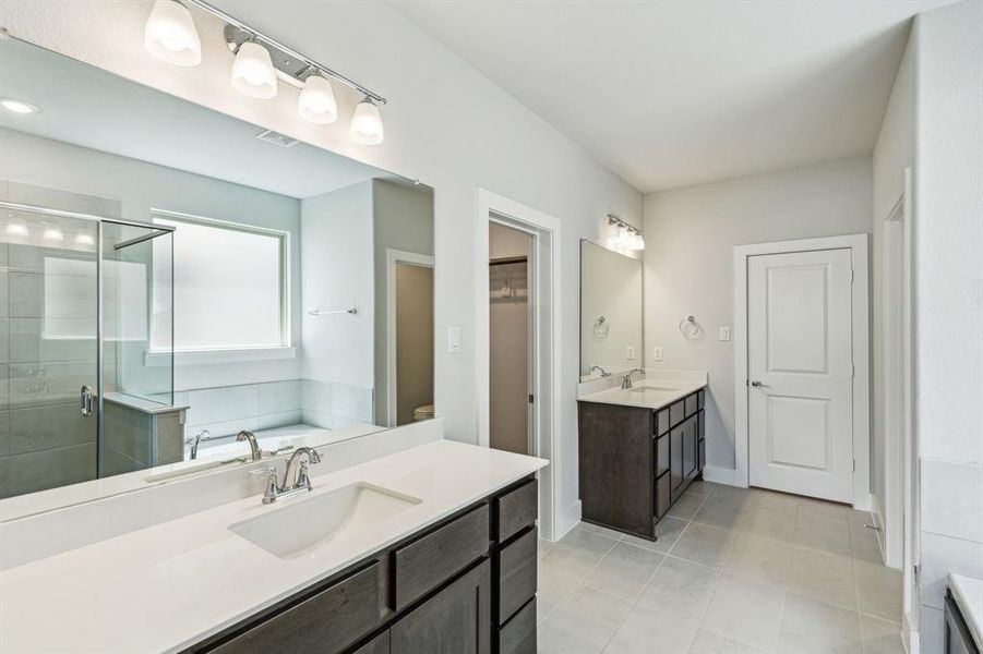 Bathroom with vanity, tile patterned flooring, and shower with separate bathtub