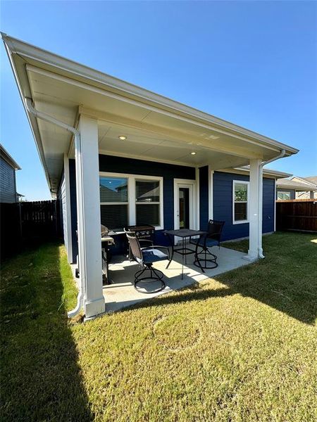 Back of house with a lawn and a patio