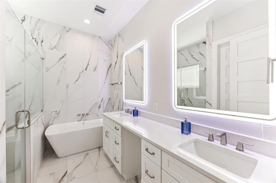 Luxurious spa-like bathroom has a freestanding soaking tub and an oversized shower.