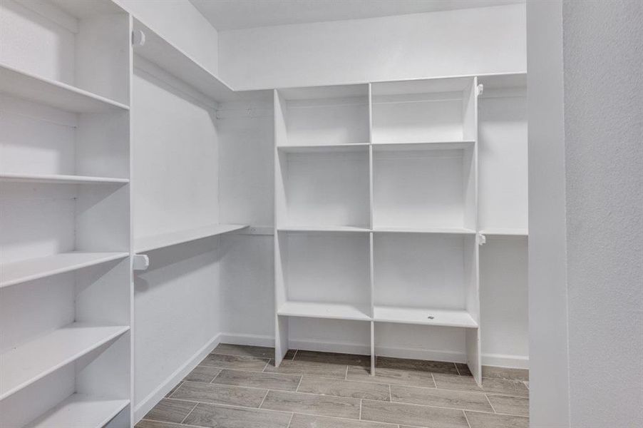 Walk in closet with light wood-type flooring