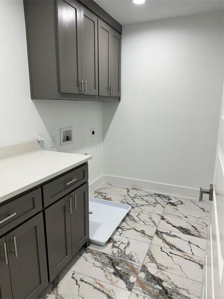 Clothes washing area with washer hookup, cabinets, and hookup for an electric dryer