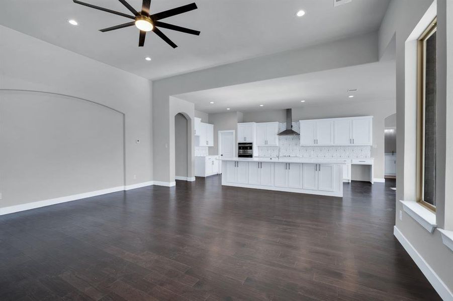 Unfurnished living room with dark hardwood / wood-style floors, sink, and ceiling fan