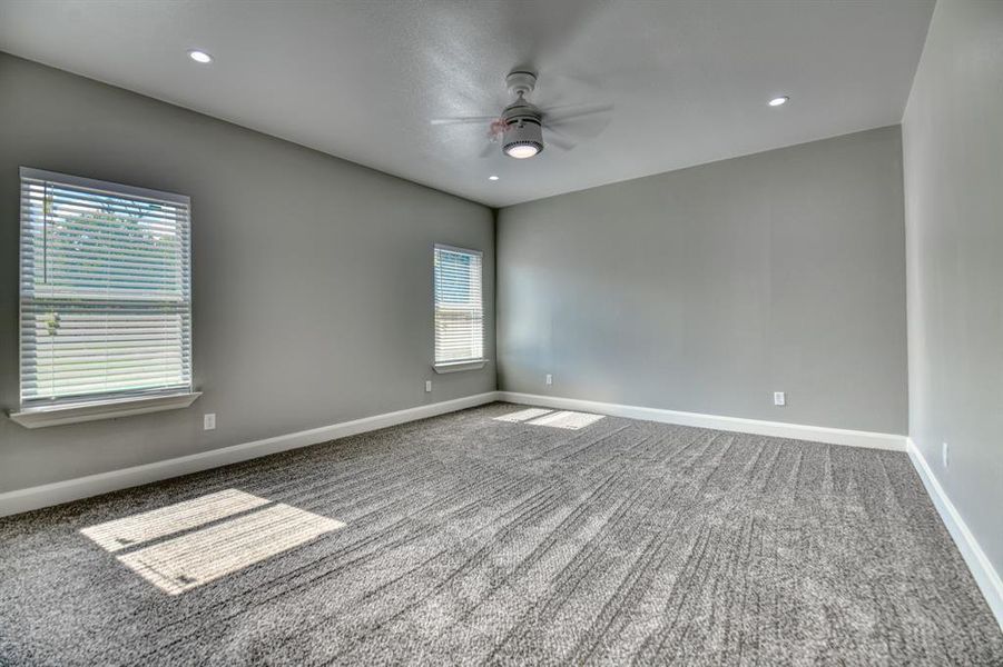 Carpeted spare room featuring ceiling fan