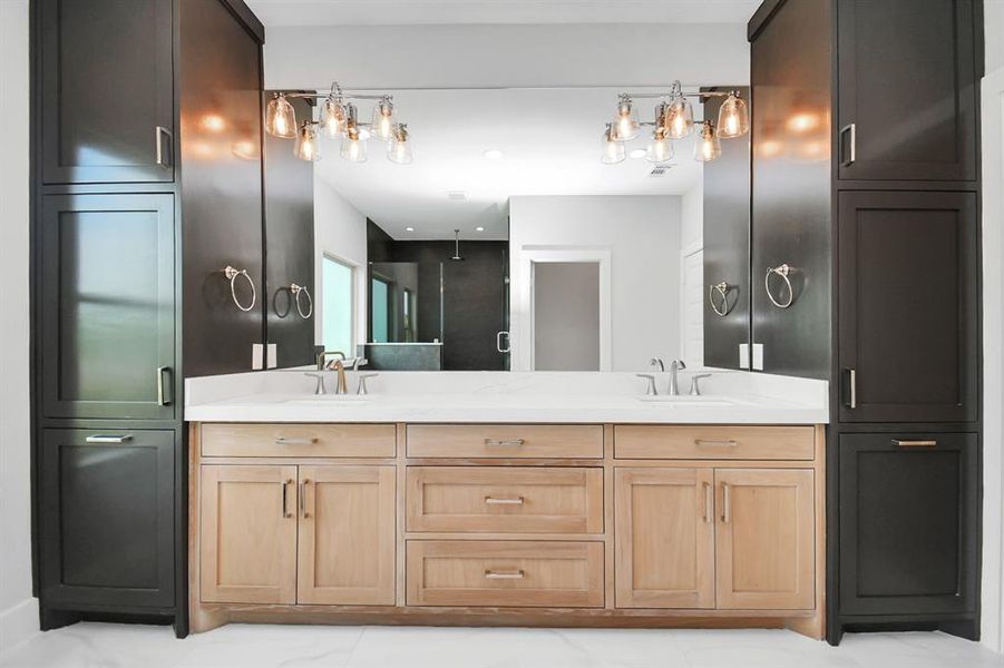 The primary suite ensuite bathroom is just beautiful! Featuring a dual vanity with extra cabinet storage on both sides, designer lighting and lovely tile flooring, this bathroom has it all!