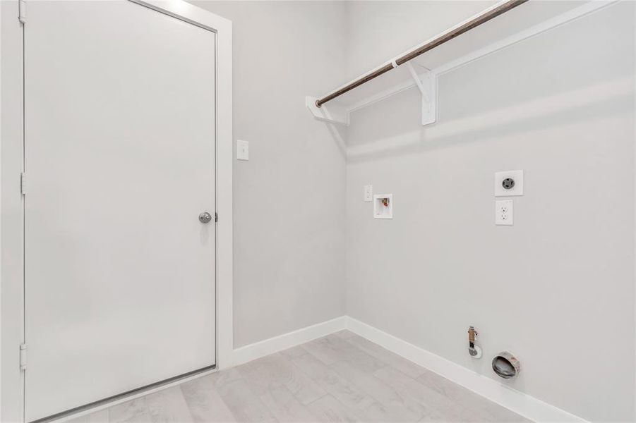 Located on first floor, a stylish laundry room where practicality meets a contemporary aesthetic. The dark finishes lend a sophisticated touch, creating a space that is both functional and visually appealing. Both electric and gas connections available. Sample photo of completed home with similar floor plan. As-built interior colors and selections may vary