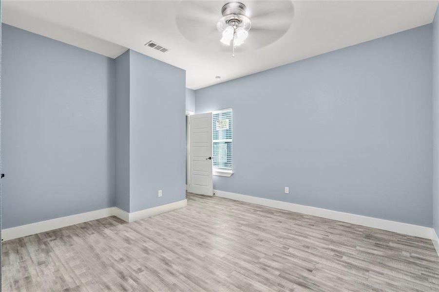 Empty room with ceiling fan and light hardwood / wood-style floors